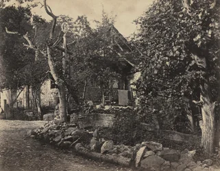 Landelijk tafereel met stenen gebouw en kruis, ca. 1857
