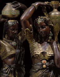 Detail van twee bronzen fakkeldragers in de vorm van Indiase vrouwen die vazen dragen