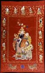 Een Chinese geborduurde rode satijnen wandkleed met een figuur met een ru-i en twee bedienden, de randen versierd met de acht onsterfelijken
