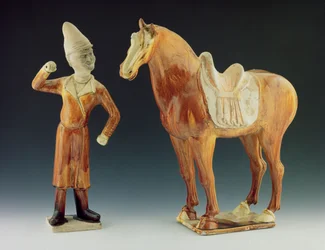 Bruidegom figuur met een jas en piekhoed met een gezadeld paard, Tang Dynastie 618-906
