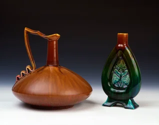 Een Linthorpe aardewerken kan van samengedrukte bolvorm met streperige karamel, groene en karmozijnrode glazuur en een Linthorpe aardewerken vaas met doorboorde bloemknopdecoratie en gevlekte groene, blauwe en bruine glazuren