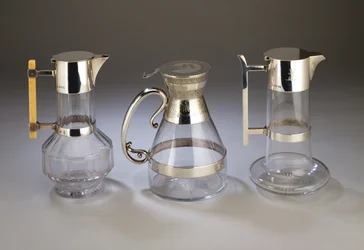 Zilveren gemonteerde wijnkan, 1882; elektroplate gemonteerde wijnkan met esthetische stijl decoratie op de monturen; zilveren gemonteerde wijnkan, 1880, allemaal vervaardigd door Hukin & Heath