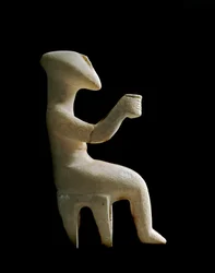 Kunst van de Cycladen: "Beeldje zittend op een kruk". Marmeren idool ingelegd met oker. Cycladische beschaving (-3200 tot -2000). Hoogte 15.2 cm. Athene, Nationaal Archeologisch Museum (inv. 3910)
