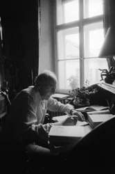 Jiri Mucha zittend aan zijn bureau in zijn huis in Hradcany, Praag