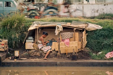 Kartonhut langs een rioolkanaal, dient als huis. Jakarta, Indonesië