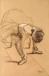 Zittende danseres die haar schoenen aanpast