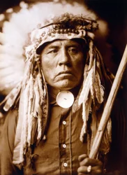 Curley, Apsaroke man, met hoofdtooi, c. 1905, foto Edward S. Curtis