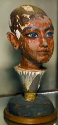 Egyptische oudheden: portret van de jonge farao Toetanchamon ondersteund door een lotusblad. Beschilderd houten beeldhouwwerk. Uit de schatkamer van Toetanchamon. Egyptisch Museum, Caïro