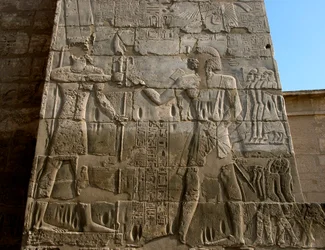Egyptische oudheden: dodentempel van Ramses III (1187-1156 v.Chr.). Laag reliëf dat de farao voorstelt die de insignes van macht ontvangt uit de handen van Amon. Luxor, Medinet Habou, Egypte