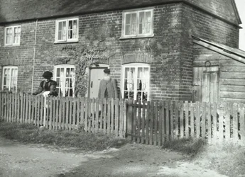 Een landelijk tafereel in de omgeving van Wandsworth met een ouder echtpaar in de tuin van een huis in cottage-stijl, Londen, 1895