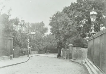 Highgate Boog: oostelijke benadering met oude lamp bevestigd aan hekwerk, 1896