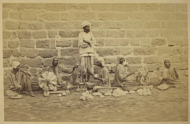 Mannelijke gevangenen die katoen op spinnewielen winden in de gevangenis van Karachi. c. 1873