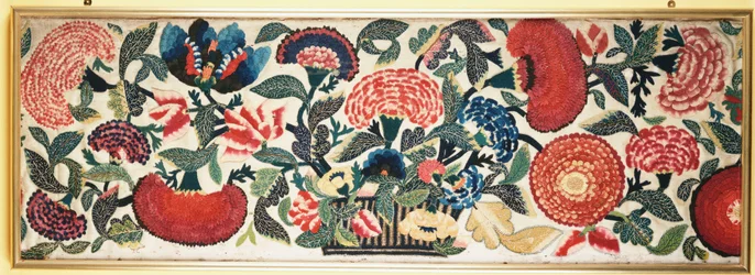 Een vilt- en applicatiepaneel met geborduurde zijden accenten die anjers, tulpen en andere bloemen uit een mand tegen een ivoorkleurige wollen achtergrond uitbeelden, c.1730-40