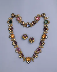 Een fijne Regency gouden en met juwelen versierde ketting met kussen geslepen topaas, amethisten, roze toermalijnen, smaragden, saffieren en peridots, met een paar bloemvormige oorbellen, c.1810