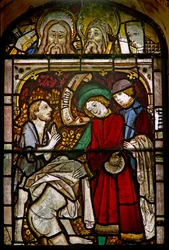 Een paneel in het oostelijke raam met de Werken van Barmhartigheid: de naakten kleden: ook enkele fijne herstelde hoofden