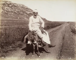Portret van een boer uit de omgeving van Haifa. De man rijdt op een ezel