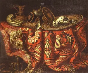 Een nautilusbeker, een pateen, kannen en een vergulde schaal op een tapijt over een rand gedrapeerd
