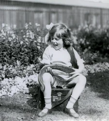 Een jong meisje Betty houdt een oostelijke indigo-slang vast terwijl ze op een leren koffer zit, London Zoo, 1924