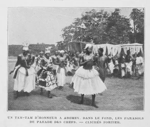 Een Tam-Tam van eer in Abomey met parasols van de hoofden op de achtergrond