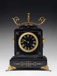 Een schoorsteenklok van zwart compositiesteen, met ingegraveerde decoratie, met poten, knoppen en beslag in verguld messing, door Jausions van Pau, Frankrijk, ca. 1876-78
