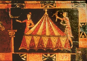 Detail van een bruidskist die twee figuren bij een tent toont