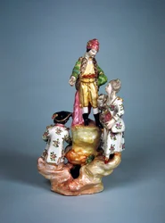 Beeldje van vier personen gegroepeerd op een rots