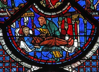 Het raam van de barmhartige Samaritaan: de Samaritaan verzorgt de gewonde man