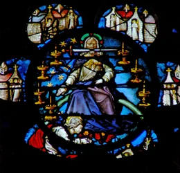 Het westelijke roosvenster met een scène uit het Boek Openbaring: Christus op een regenboog omgeven door zeven gouden kandelaren en de zeven kerken van Azië. In zijn mond is het scherpe tweesnijdende zwaard