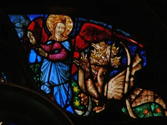 Het westelijke roosvenster met een scène uit het Boek Openbaring: draak vervolgt de moeder van het mannelijke kind; maar zij heeft vleugels om naar de woestijn te vliegen (12:13-14)