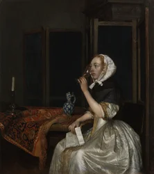 Jonge vrouw met een glas wijn, met een brief in haar hand