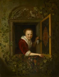 Een meisje met een druiventros bij een raam