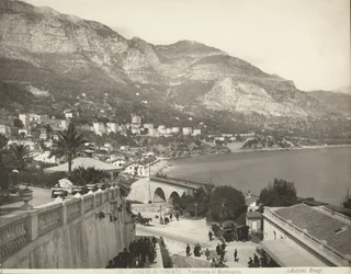 Panoramisch uitzicht op Montecarlo in Monaco. De scène toont verschillende voorbijgangers; links zien we een close-up van een marmeren balustrade