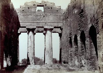 Interieur van de Tempel van de Concordia in de Vallei van de Tempels in Agrigento. Op de voorgrond twee Dorische zuilen; aan de zijkanten een gebogen perimeterwand