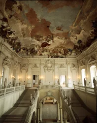Uitzicht op de Grote Trap en plafond gedecoreerd door Giovanni Battista (Giambattista) Tiepolo (1696-1770), die de Allegorie van de Vijf Continenten vertegenwoordigt. 1753 Paleis van Würzburg gerealiseerd door architect Johann Balthasar Neumann (1687-1753)