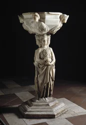 Wijwaterbak aan de pilaar versierd met de drie theologische deugden en de kuip versierd met de bustes van de vier kardinale deugden