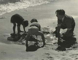 Drie kinderen spelen met zand op het strand