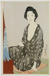 Een schoonheid in een zwarte kimono met witte hanabishi-patronen, zittend voor een spiegel, 1920
