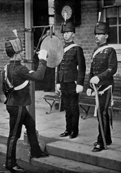 Het slaan van de gong bij de hoofdingang van de cavaleriekazerne van Aldershot, Hampshire