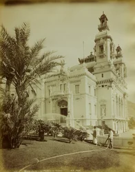 Het theater naast het Casino in Montecarlo. Op de voorgrond een uitzicht op de tuin versierd met palmbomen