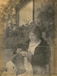 Vrouw die een kanten jurk naait, Italië, ca. 1910
