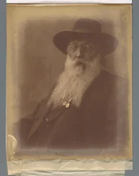 Portret van een man met baard en hoed en een sigaar in de mond