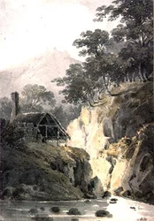 Rotsachtig landschap in Cornwall, met ruïnes van een kasteel in de verte