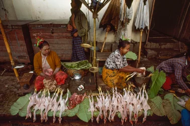 Voedselverkopers met gezichten versierd met thanaka, poedervormige boomschors. Taunggyi, Birma