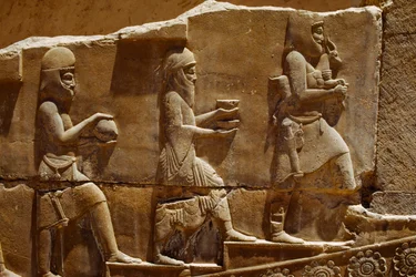 Reliëfsculptuur van mannen die offers dragen op de muren van Persepolis. Persepolis, Iran