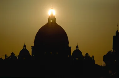 Zonsondergang achter de koepel van de Sint-Pietersbasiliek. SINT-PIETERSBASILIEK, VATICAANSTAD.
