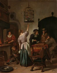 Interieur met een vrouw die een papegaai voert, bekend als 