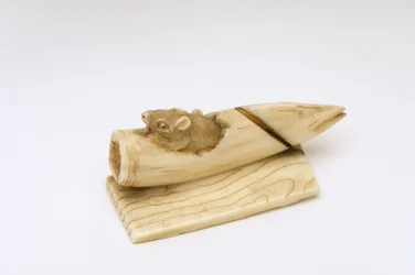 Netsuke van een muis die uit een bamboescheut komt