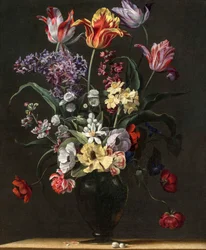 Tulpen, lelies, narcissen, seringen en andere bloemen in een glazen vaas op een houten rand