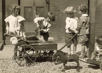 Jonge kinderen die grind in een kar laden