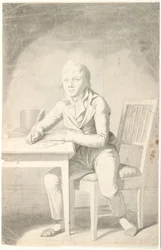 Jonge schrijvende jongen zittend aan een tafel